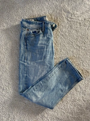 Ljusblå raka Jack & Jones  jeans 29/30 - Säljer ett par klassiska ljusblå jeans med rak passform och fem fickor. Jeansen har en tidlös look med normalhög midja och är tillverkade i denim. Perfekta för dig som gillar en avslappnad och enkel stil.