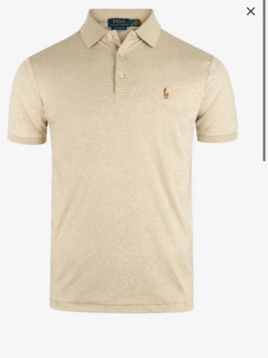 Beige pikétröja från Polo Ralph Lauren - Klassisk beige pikétröja från Polo Ralph Lauren. Stilren och perfekt för sommaren till för en go outfit. Inga defekter eller fläckar.