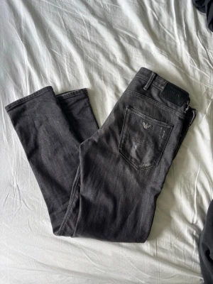 Armani Jeans - Svart gråa Armani jeans med snygga slitningar. Storlek 30 30 och sitter slim. 