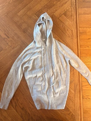 Kasmir hoodie från Marks & Spencer/autograph - Mysig ljusgrå hoodie från Marks & Spencer/autograph i mjuk kashmirblandning. Tröjan har dragkedja framtill, två fickor och ribbade muddar vid ärmslut och nederkant. Perfekt för chill dagar och har en stor huva med dragsko. Pris kan diskuteras! 💕