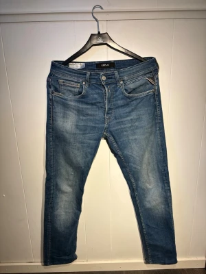 Blå jeans från Replay - Snygga blå jeans från Replay med lätt slitna detaljer. W30 L32, men uppsyda till L30. Vilket ger en bättre passform än L30 orginal. Jeansen har raka ben och normal midja, tillverkade i mjukt denimtyg. Grymt inför sommarens lite kyligare kvällar!