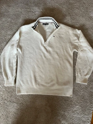 Vit quarter zip från Tommy Hilfiger  - Säljer denna vita stickade tröja från Tommy Hilfiger som är perfekt för dig som är ute efter en clean och stilren look.