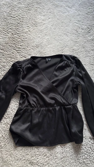 Svart omlottblus från Vero Moda - Så otroligt snygg och elegant bluse ifrån vero Moda. Använd en gång. Super bra skick.💞