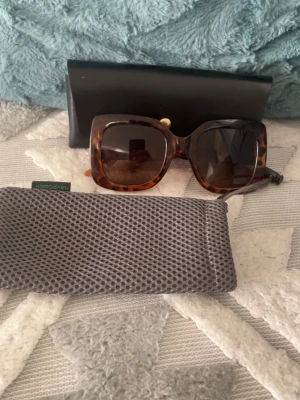 Stora fyrkantiga solglasögon leopard - Snygga solglasögon med stora fyrkantiga bågar i leopardmönster. Kommer med svart hårt fodral och ett grått mjukt fodral. Perfekta för att ge en trendig touch till din look.