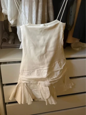 Vit kort klänning med volang - Supersöt vit kort klänning med volangkant nertill och figurnära passform. Klänningen är ärmlös och har en enkel, stilren design som passar perfekt till sommaren. Klänningen är från Zara som inte säljs längre! Vit/ cremebeige och använd ett fåtal gånger så bra skick!❣️❣️Storlek M, men är ganska kort så passar en S också! Jag är 170 cm som referens! 