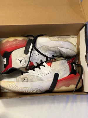 Jordan Why Not Zer0.3 vita/röda sneakers - Snygga Jordan Why Not Zer0.3 sneakers i vitt, rött och svart med mesh och syntetmaterial. Skorna har svart snörning, tydlig Jumpman-logga och en chunky sula med Zoom-dämpning. Perfekta för dig som gillar basketinspirerad streetstyle.