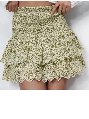 Svin snygg kjol med broderi - Supersöt kort volang kjol me gröna blommor och broderi. Bra skick! Storlek s