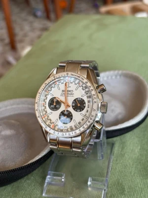 Seiko kronografklocka i silver - Stilren Seiko kronografklocka med vit urtavla, tre svarta subdials och tachymeter-skala. Klockan har robust armband i rostfritt stål och tydliga visare med roseguld sekundvisare. Perfekt accessoar för dig som gillar sportig och klassisk stil.