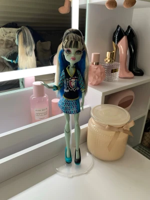monster high frankie G1 - frankie doll monster high g1 gouhl. Har rengjort hela och lagt ner mycket tid på håret ”boil wash” så de är fint.  Man får med hållaren som håller upp dockan också på köpet. Försökte inte lägga ut för dyrt men eftersom jag har lagt ner typ 1 och en halv timme på att få dockan så fin som möjligt så är det detta priset.
