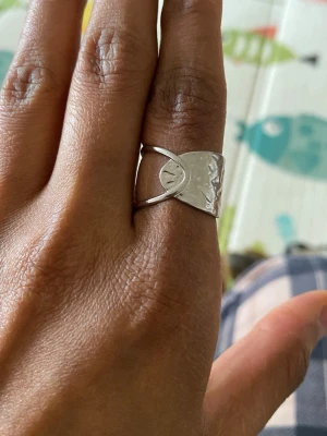 Snygg rostfritt stål ring - Unik ring med en halvmåneformad  som ger en cool och modern look. Ringen är öppen och justerbar, vilket gör den enkel att bära på olika fingrar. Perfekt för dig som gillar stilrena accessoarer med en twist.