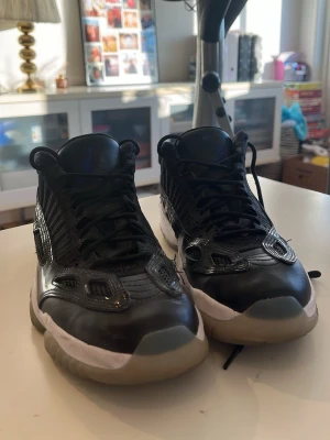Svarta Air Jordan 11 sneakers lows - Snygga svarta Air Jordan sneakers med lågt skaft och vita detaljer runt sulan. Ovandelen är i läder och mesh för en cool look och bra andningsförmåga. Sulan är genomskinlig och ger en sportig vibe. Perfekta för dig som gillar streetwear och basketstil.