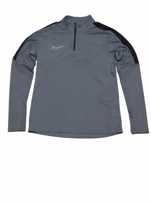 Grå långärmad träningströja Nike - Grå långärmad träningströja från Nike med halv dragkedja och svarta detaljer på axlarna. Broderad Nike-logga i ljusgrönt på bröstet. Perfekt för träning eller uppvärmning. Tillverkad i ett lätt och stretchigt funktionsmaterial.