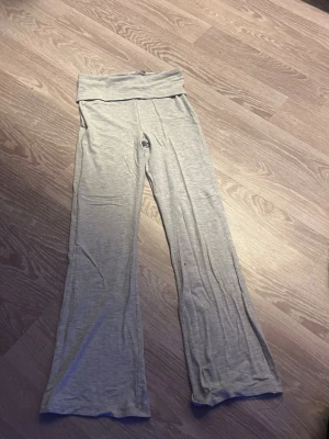 Grå mjuka bootcut leggings - Säljer ett par grå leggings med bootcut-modell och bred linning i midjan. Tillverkade i ett mjukt och stretchigt material som känns skönt mot huden. Perfekta för en avslappnad och chill stil.