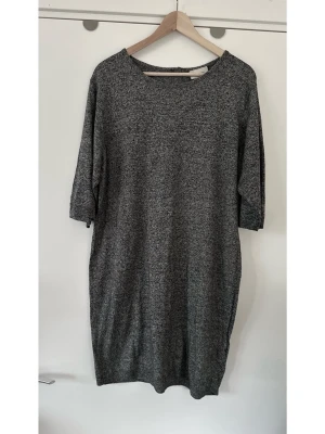 Grå stickad MONKI klänning med dragkedja, L - Grå melerad stickad klänning från Monki i storlek L. Stilren modell med trekvartsärm och dragkedja baktill i nacken. Klänningen har en rak passform och rundad halsringning. Bomull och viskos-blandning, så bra material som andas. Mycket fint skick!  Skickas mot porto, kan även hämtas i Stockholm. 