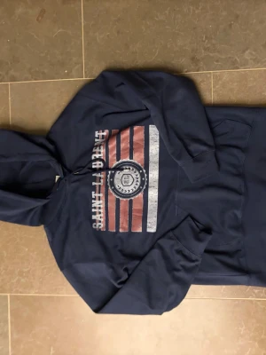 Mörkblå Saint Laurent hoodie - Snygg mörkblå hoodie från Saint Laurent med huva. Storlek M men är mindre i storleken så passar XS/S. Den är lite för liten på mig och jag är 173cm lång.  Helt ny med tags. Kontakta vid intresse så kan pris diskuteras!👌
