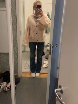 Blå bootcut jeans från Levi’s - Säljer ett par klassiska blå bootcut jeans från Levi’s. Jeansen har en lätt tvättad look med subtila slitningar och femficksdesign. De är tillverkade i bomullsdenim och har en bekväm passform som är smal upptill och utsvängd nedtill.