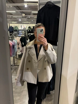 Kort beige trenchcoat - Säljer då jag vill köpa en grön men denna är helt utan defekter då den d använd ca 4 gånger. Perfekt nu till våren