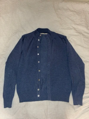Stenströms Cardigan - Tunn mellanblå stenströms kofta i strl M men passar S. Mycket bra skick, minimal hållagning på ryggen som ej märks av vid användning. 100% merinoull. Nypris ~ 2500kr. Kom gärna med prisförslag!