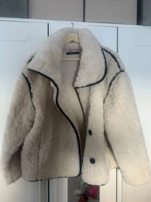 Vit teddyjacka från Gina Tricot - Supermysig vit teddyjacka från Gina Tricot med oversized krage och svarta detaljer längs kanterna. Aldrig använt 💕