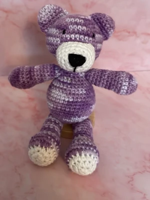 Virkad lila nallebjörn - Söt handvirkad nallebjörn i lila och vitt garn. Nallen har rund mage, utstickande öron och broderad nos i svart. Perfekt som dekoration eller present till någon som gillar gulliga saker. Sittande 11 cm