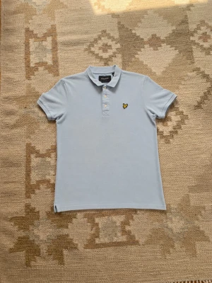 Ljusblå piké från Lyle & Scott - Säljer en ljusblå pikétröja i storleken L från Lyle & Scott den är i mycket bra skick till ett bra pris.