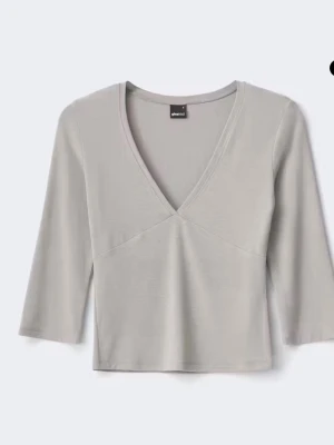 Ljusgrå v-ringad topp - Snygg ljusgrå topp med v-ringning och trekvartsärm. Enkel och stilren design som passar till det mesta. Tillverkad i mjukt material för en bekväm känsla. (Bilder kan skickas privat) aldrig använd endast provad 