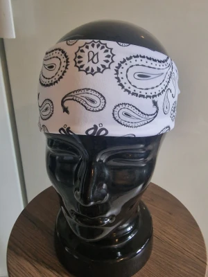 Bandanas/hårband vit - Bandanas/hårband cashewnöt. Elastisk. 50 cm huvud. Trikåtyg. Elastisk. Andningsbar. Rynkfri. Polyester.