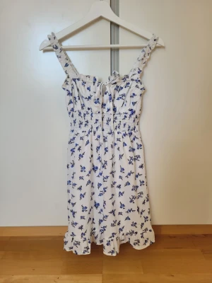 Vit blommig klänning Shein - Söt vit klänning från Shein med blått blommönster. Köpt för 189 kr.