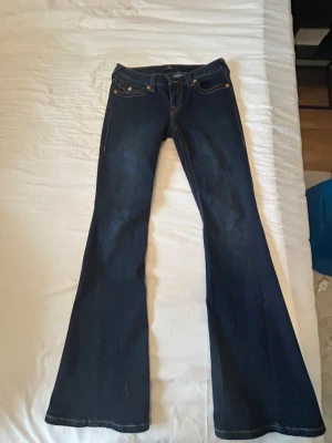 True Religion mörkblå bootcut jeans - Säljer ett par mörkblå bootcut jeans från True Religion i storlek 27, de har använts 2 gånger och har bara tvättats en gång.