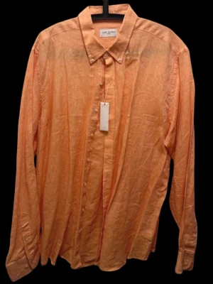 Linneskjorta från John Henric - Snygg orange skjorta från John Henric i luftigt linne. Klassisk krage, knappar framtill och långa ärmar med knapp vid manschetten. Perfekt för dig som vill ha en stilren och bekväm skjorta med avslappnad känsla. Nypriset var 999 kr, lapparna finns fortfarande kvar. 
