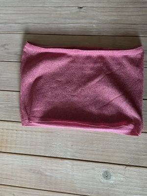 Rosa bandeau tubtopp från NA-KD - Säljer en rosa bandeau tubtopp från NA-KD. Toppen är ärmlös och har en enkel, clean design i mjukt material. Perfekt att styla med höga jeans eller kjol för en trendig look.