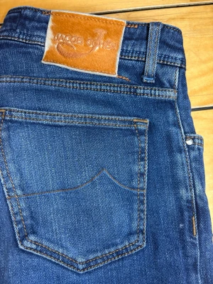 Jacob Cohën 622 Slim Fit Jeans – W33 – Made in Italy - Jacob Cohën 622 jeans i mörkblå tvätt. Tillverkade i Italien med premiumdenim och stretch för hög komfort. Slim fit-modell med snygg passform som passar både vardag och mer uppklädda outfits.  Storlek: W33 Modell: 622 Passform: Slim fit Skick: Mycket bra skick  Nypris ligger ofta runt 4 000–6 000 kr.  Skriv vid frågor eller om du vill ha fler bilder/mått. Snabb affär prioriteras.