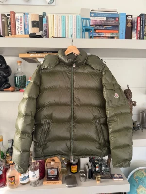 Olivgrön Moncler Maya -  Har inte kvar kvittot. Vänligen fråga om mer bilder eller om ni har några andra frågor om ni är intresserade det är storlek 3 så typ en medium large
