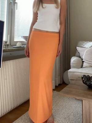 Jättefin orange ribbad långkjol  - Säljer denna jättefina orangea maxikjol i mjukt och stretchigt material. Den sitter kroppsnära och är väldigt bekväm att bära. Perfekt till sommaren, semester eller en kväll ute. Kan stylas både upp och ner med toppar, skjortor eller stickat🤍 Storlek S