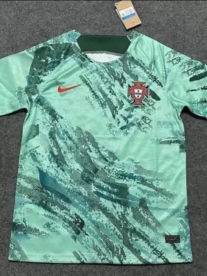 Portugal fotbollströja Nike grön - Snygg Portugal fotbollströja från Nike i mintgrönt med abstrakt mönster i mörkare gröna toner. Tröjan har rund halsringning, korta ärmar och Portugal-emblemet på bröstet. Tillverkad i lätt och ventilerande material, perfekt för träning eller match.