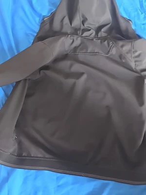Svart vindjacka från Sail Racing - Snygg svart vindjacka från Sail Racing med huva och diskreta sömmar. Jackan har en stilren design och är tillverkad i ett vindtätt material som passar perfekt för blåsiga dagar. Märkeslogga på insidan och praktisk passform.