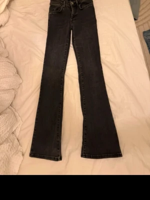 Svarta bootcut jeans mid waist från bikbok - Säljer ett par svarta bootcut jeans . Jeansen har en snygg utsvängd passform och är tillverkade i denim. Perfekta för dig som vill ha en trendig siluett och gillar retrovibbar.