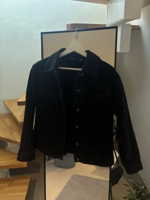 Svart jeansjacka från H&M - Snygg svart jeansjacka från vila med klassisk krage, knäppning framtill och två bröstfickor. 