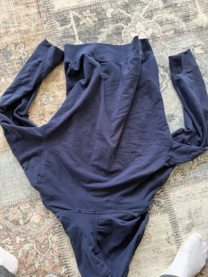 Mörkblå hoodie från Polo Ralph Lauren - Snygg mörkblå hoodie från Polo Ralph Lauren med dragkedja framtill, två stora fickor och klassisk huva med dragsko. Tillverkad i mjuk bomull för skön känsla. Liten vit logga broderad på ena fickan. Perfekt för en avslappnad och stilren look.