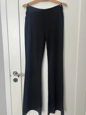 Svarta utsvängda leggings med snörning - svarta leggings med utsvängda ben och snygg snörningsdetalj i midjan. 