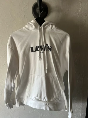 Vit hoodie från Levi's - Säljer en vit hoodie från Levi's då den aldrig används längre. Har en fläck på baksidan och vet inte vart det kommer ifrån men ska nog gå bort i tvätten.
