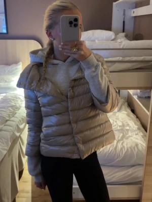 Beige pufferjacka från Herno - Snygg beige trekvartsjacka från Herno med glansig finish och bred krage. Jätte snygg och i nyskick. Sitter som s men funkar för mig som har xs
