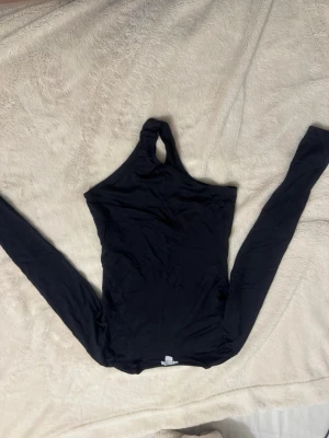 Svart body vanlig mysig tröja från märket Amisu storlek S - Snygg svart body ifrån AMISU köpt på ”newyorker i Tyskland”. Tillverkad i mjukt och stretchigt material som sitter tight mot kroppen. Perfekt för dig som vill ha en trendig och unik look.