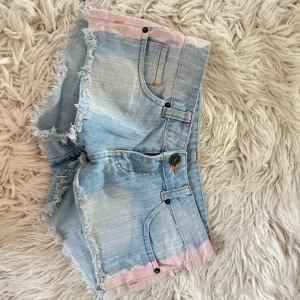 A4(td) Lågmidjade jeansshorts med rosa kant - Midja ca 37 cm rakt över! Jättefina men tyvärr är dragkedjan trasig men det märks inte när man har på sig de då dragkedjan täcks när de är knäppta (se sista bilderna)! Därav priset💞uppskattad storlek som en relativt liten xs