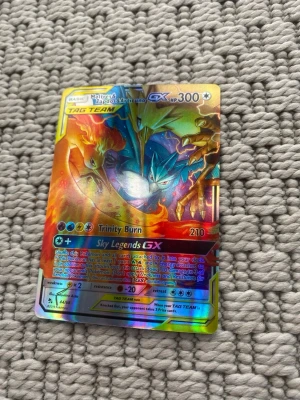 Pokémonkort Moltres Zapdos Articuno GX - Säljer ett färgstarkt och glansigt Pokémonkort med Moltres, Zapdos och Articuno GX TAG TEAM. Kortet har coola illustrationer i blått, rött och gult och är tillverkat i klassiskt Pokémonkort-material. Perfekt för samlare eller dig som vill boosta din lek!
