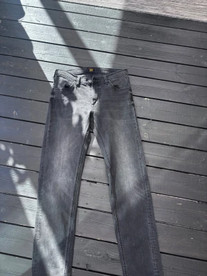 Grå Lee Daren Zip Fly jeans W30 L32 - Säljer ett par grå jeans från Lee, modell Daren Zip Fly. Klassisk femficksdesign, dragkedjegylf och raka ben. Jeansen är tillverkade i bomull och har en snygg tvättad look som passar till det mesta.
