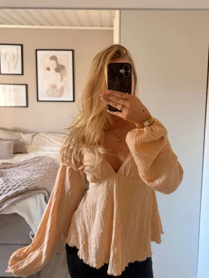 Aprikos blus/topp - Superfin topp med öppen rygg, använd 1 gång och köpt på na-kd. Ryggen går att ställa in med banden!!