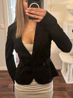 Svart figursydd kavaj - Supersnygg kort kavaj med snygga detaljer. Storlek S men går att justera tightare också!☺️