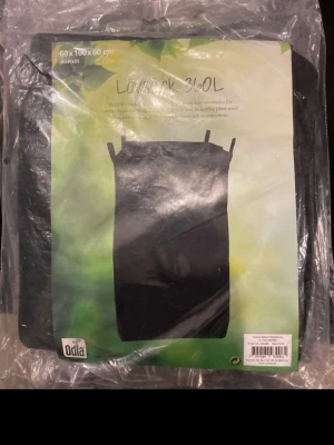 Svart lövsäck 360L från Odla - Stor svart lövsäck på 360 liter från Odla, perfekt för trädgårdsarbete. Mått 60x100x60 cm. Tillverkad i slitstarkt material och har handtag upptill för enkel hantering. Kommer i förpackning.