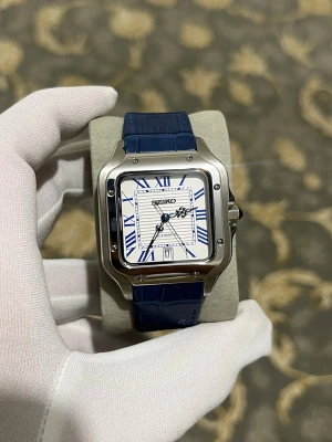 Seiko Santos- marinblå leder  - Snygg Seiko klocka med fyrkantigt silverfärgat stainless steel boett, vit urtavla och blå romerska siffror. Klockan har blått läderband och datumvisning vid klockan 6. Automatiskt urverk och coola detaljer på visarna.